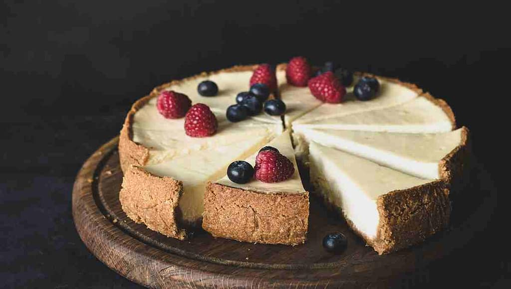 Вкусный чизкейк с малиной и черникой на деревянной доске